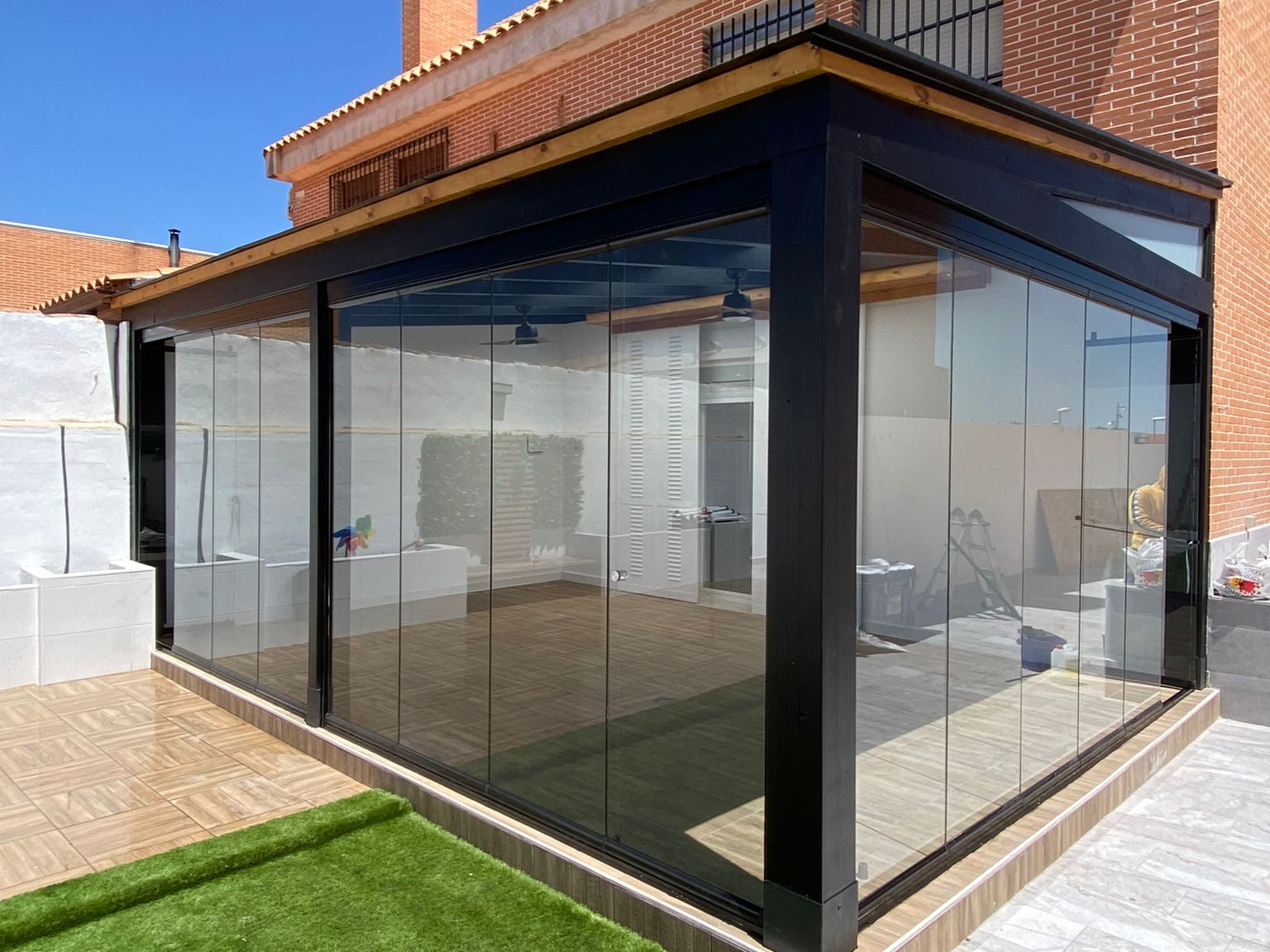 Porche con tragaluz y cortinas de cristal.