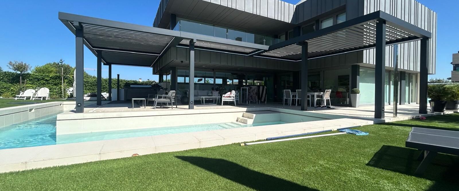 chalet-moderno-pergola-bioclimatica En la imagen se ve una casa de estilo futurista con una pergola bioclimatica