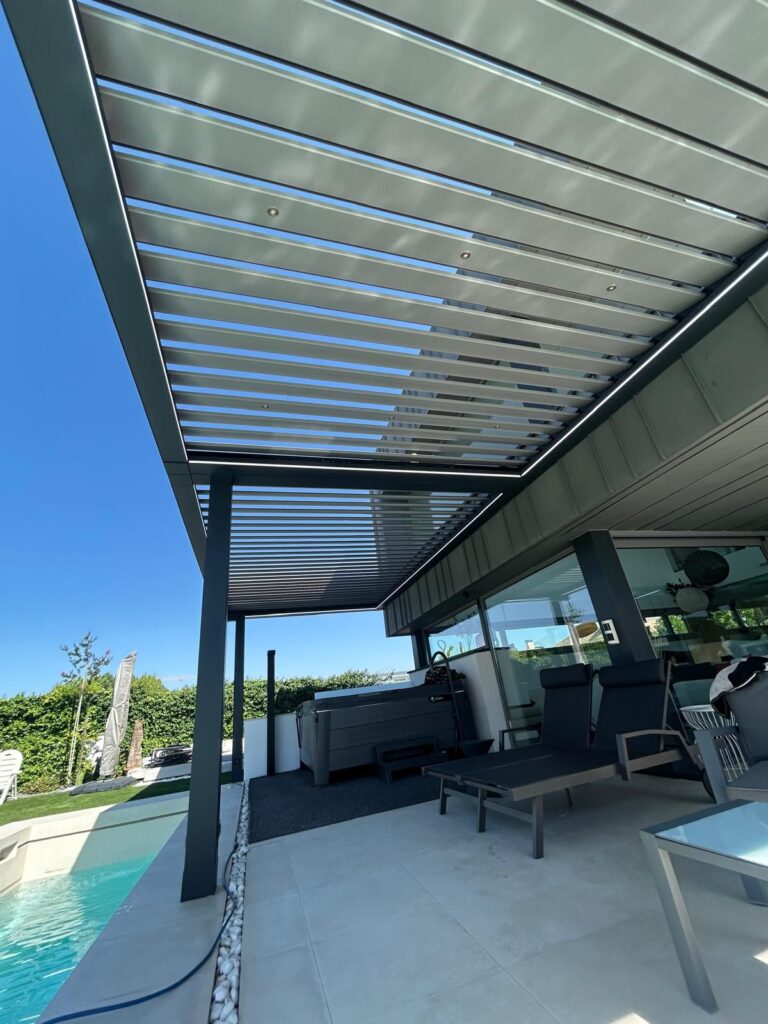 En la imagen se ve una pergola bioclimatica junto a la piscina