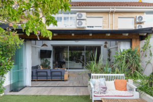 En la imagen se ve un porche de madera ampliando el salon en un chalet adosado de estilo moderno