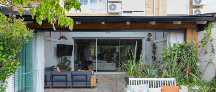 porche-rustico-casa-moderna En la imagen se ve un porche de madera ampliando el salon en un chalet adosado de estilo moderno