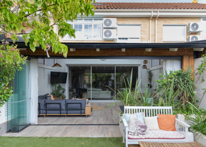 porche-rustico-casa-moderna En la imagen se ve un porche de madera ampliando el salon en un chalet adosado de estilo moderno