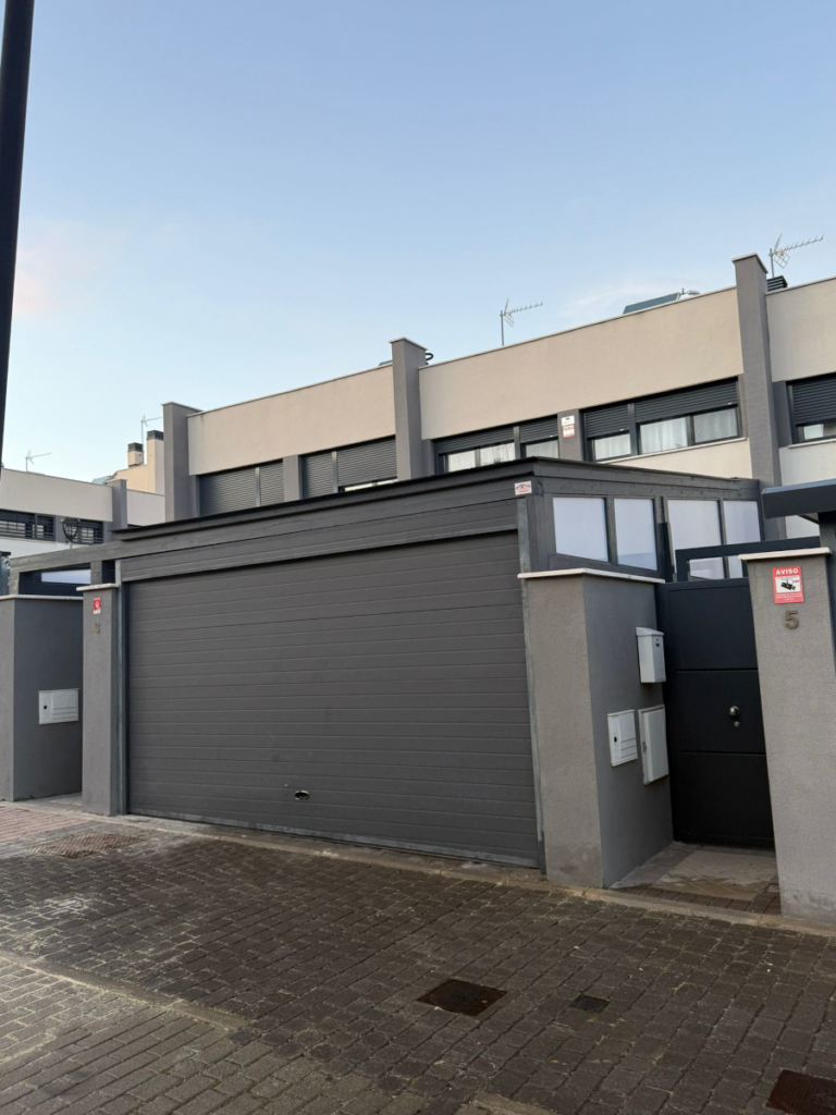 En la imagen se ve una pergola para coches, carport desde el exterior de la fachada