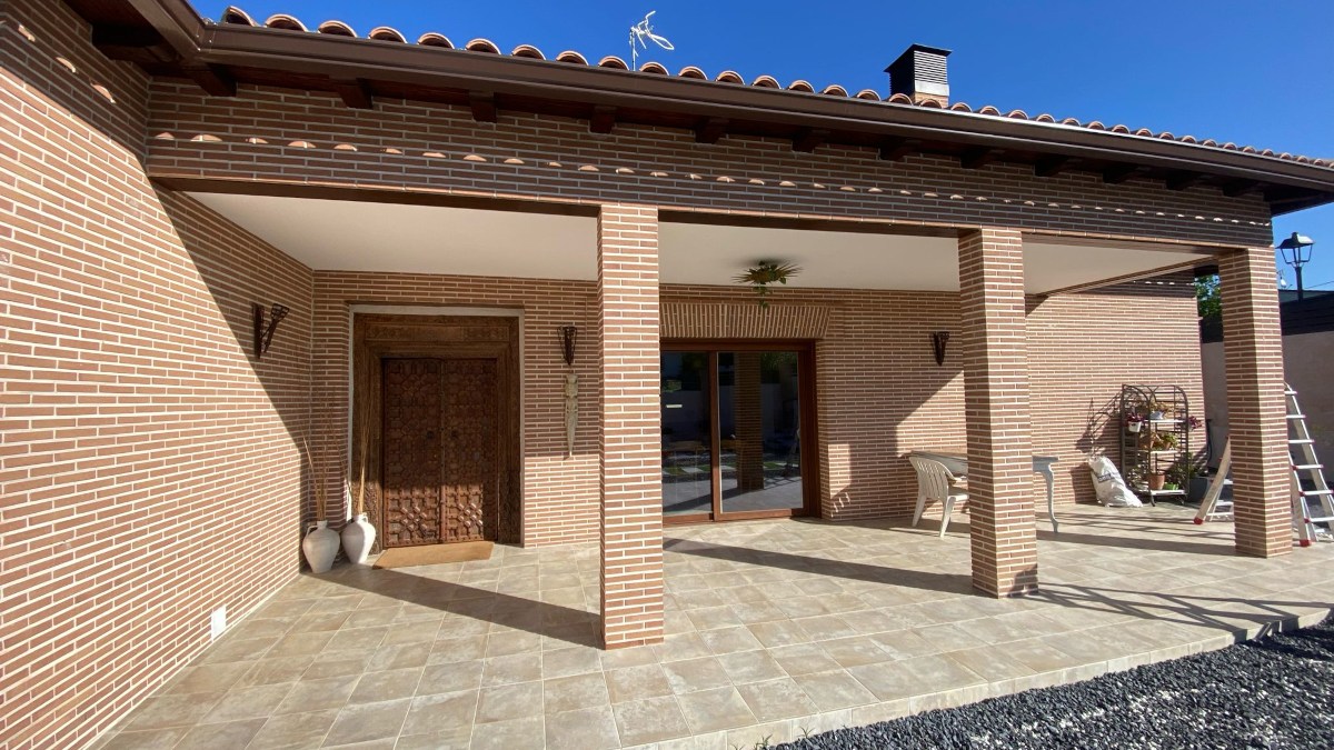 En la imagen se ve el porche de ladrillo antes de colocar la cortina de cristal