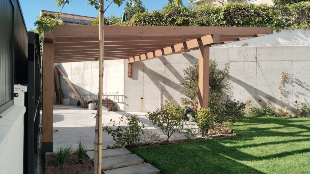 En la imagen se ve una pergola de madera construida a medida en un paso de carruajes