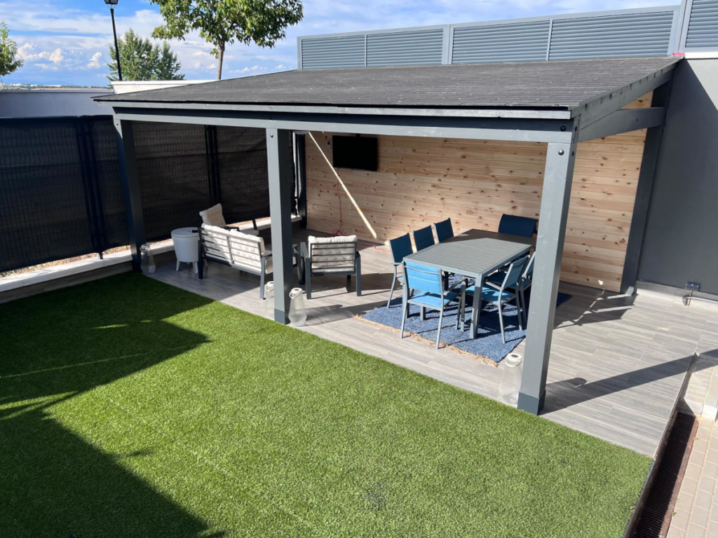 En la imagen se ve un porche de madera adosado terminado