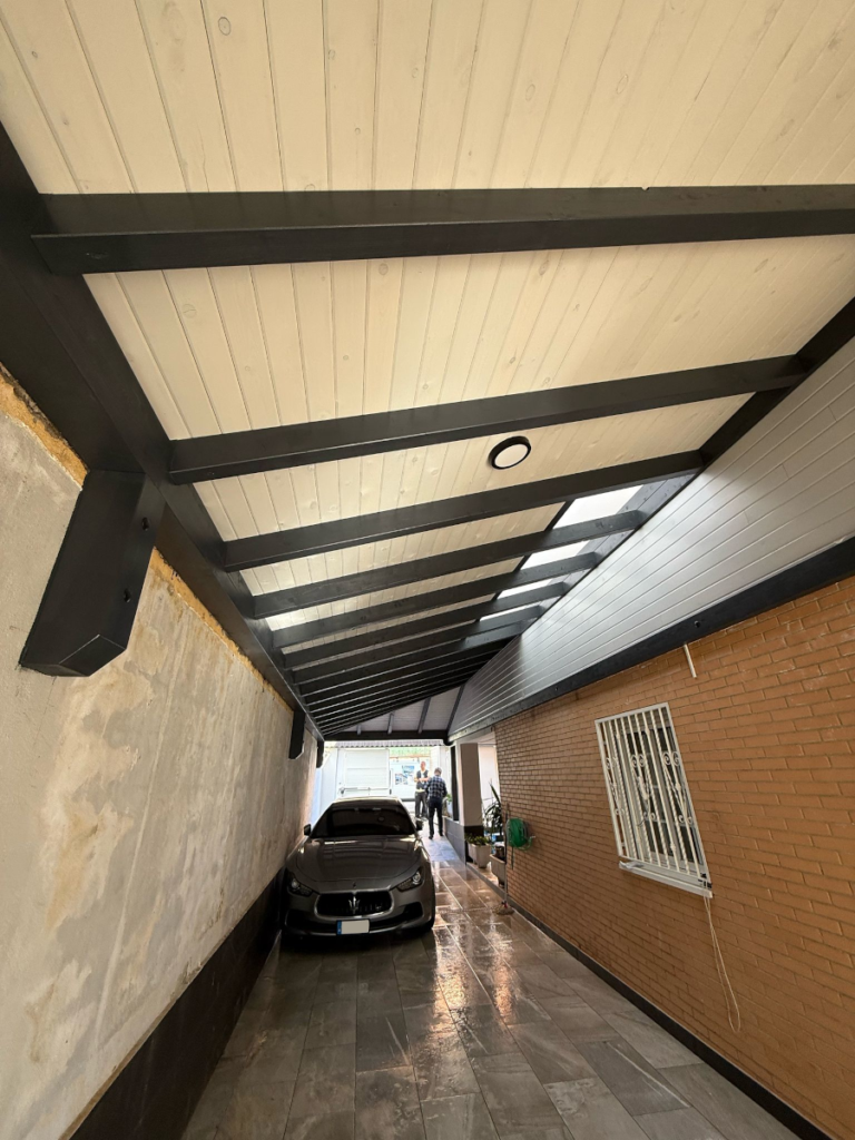 En la imagen se ve un porche cubriendo la entrada de carruajes con tragaluz acristalado