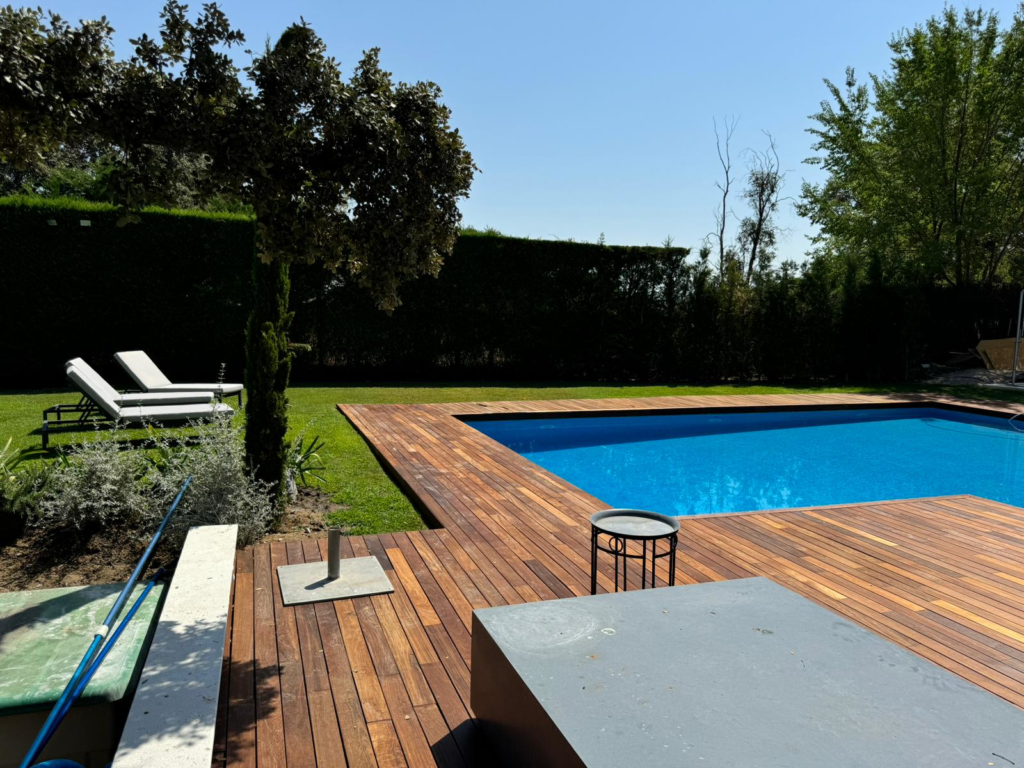 En la imagen se ve una piscina rodeada de tarima de ipé tratada con aceite de teca