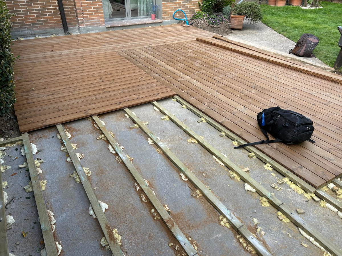 En la imagen se ve el proceso de instalacion de una tarima de exterior sobre rastreles de madera