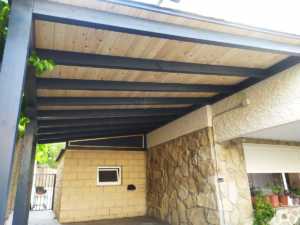 En la imagen se ve el detalle de un porche a un agua en el paso de carruajes con la tabla de color transparente