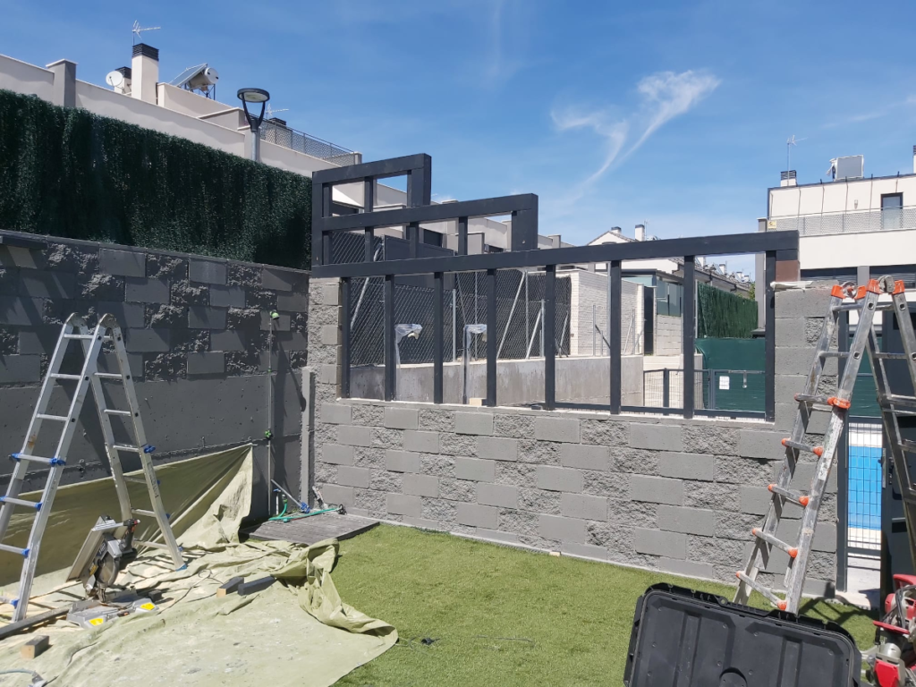 En la imagen se ve la estructura de la valla de madera sobre bloque de hormigon