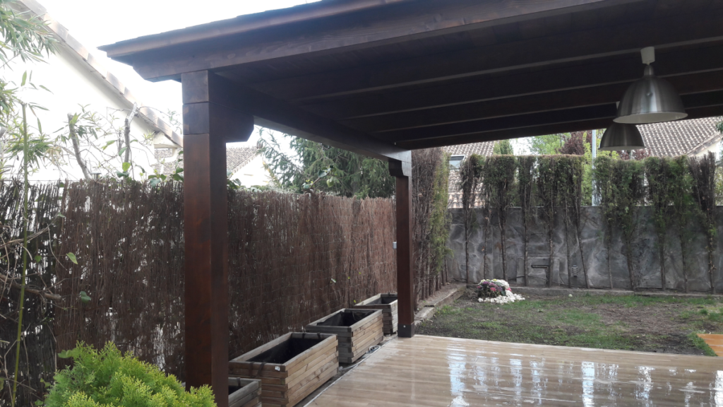 En la imagen se ve el detalle de los pilares del porche de madera apoyados en la losa de hormigon para repartir las cargas