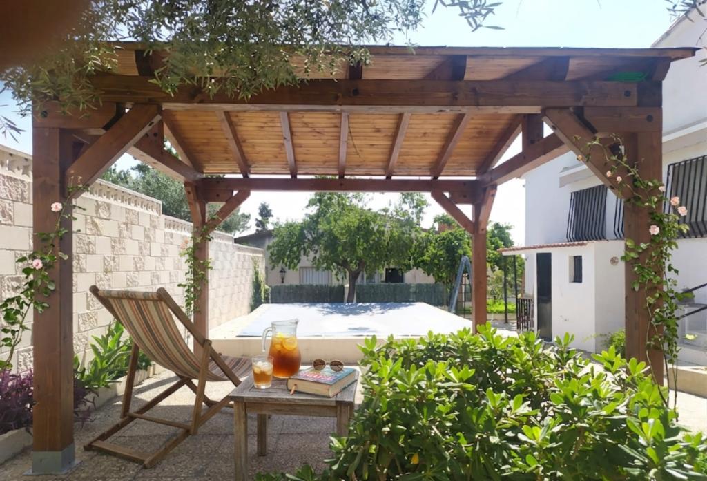 En la imagen se ve una tumbona debajo de un porche