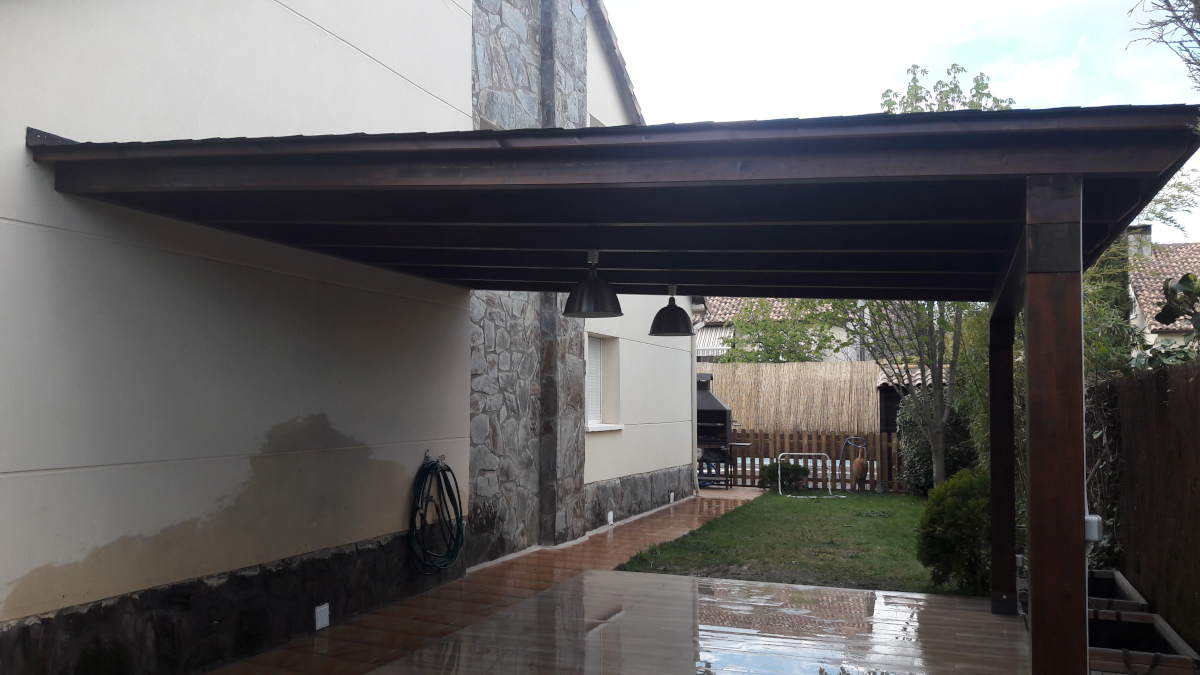 En la imagen se ve un porche de madera de un agua adosado a una vivienda en la localidad de Alpedrete, Madrid