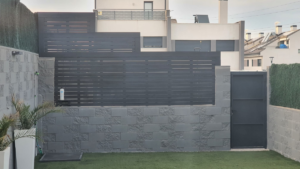 En la imagen se ve una valla de madera sobre un muro de bloques