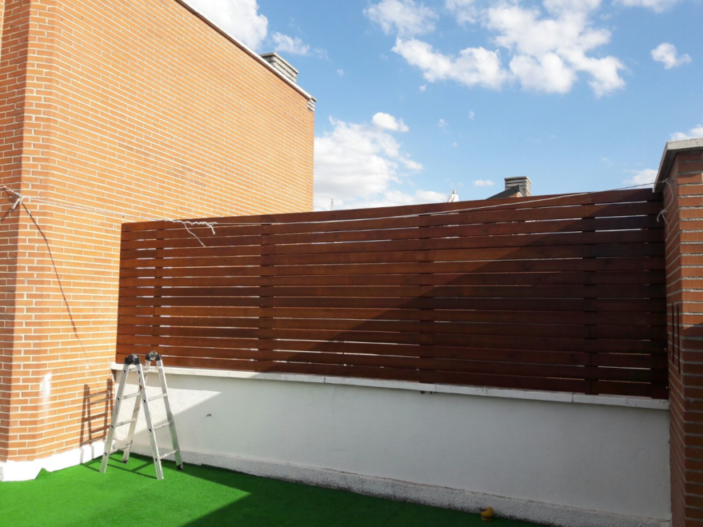 En la imagen se ve un parapeto de madera para separar las zonas de los vecinos