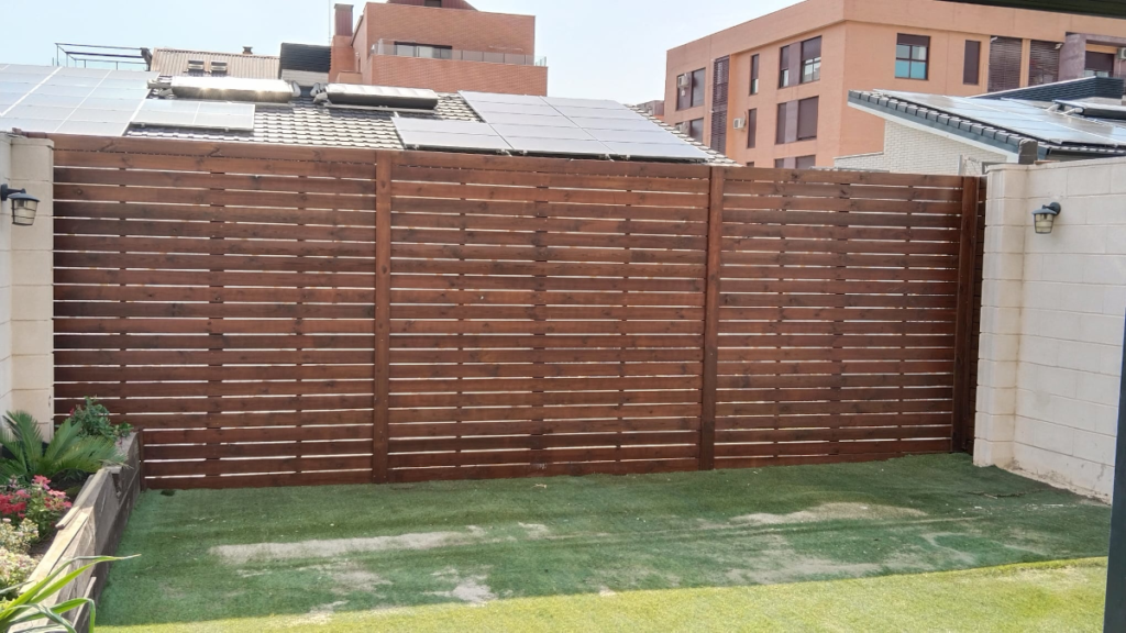 En la imagen se ve una valla de madera estilo celosia fabricada a medida